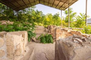 Preserved remains of the ancient royal bath structure at Armaziskhevi site, surrounded by greenery under protective roof in Mtskheta region, Georgia photo
