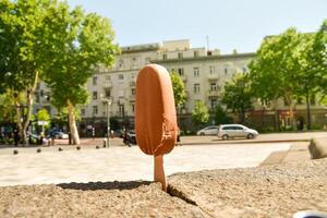 close up ice cream melts in very hot summer day in direct sunlight. Concept heat wave summer holidays extreme temperatures and global warming affects photo