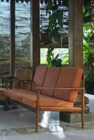 Vintage Sofa on Tiled Floor with Bamboo Screen and Lush Greenery View photo