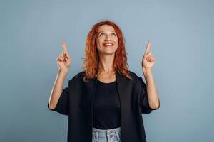With fingers up, showing. Woman is in the studio against background photo