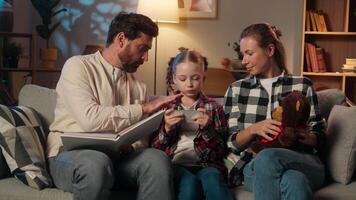 Caucasian family problem at evening home kid child daughter girl dependency addiction of mobile phone ignoring parents showing toy and book talking digital dependence bad behavior lack of attention video