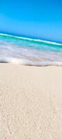 A beach with a wave coming in on the sand photo