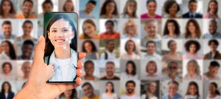 A hand holds a smartphone displaying a face recognition scan of a person. In the background, a collage of diverse faces emphasizes the application of identification technology today. photo