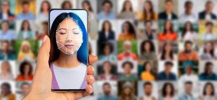A hand holds a smartphone displaying a facial recognition scan of a woman. In the background, a collage of diverse portraits highlights the evolution of identification technology. photo