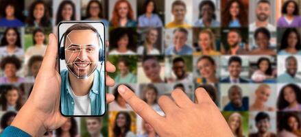A person scans their face using a smartphone while surrounded by a diverse collage of facial portraits. This shows the advancement of face recognition technology in daily use. photo