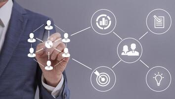 E-business concept. Unrecognizable entrepreneur touching white icons representing online business process on interactive screen, grey background photo