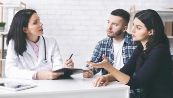 Attentive married couple listening to doctor prescriptions, asking about diagnosis, free space photo