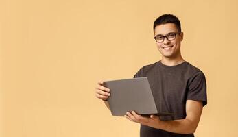 Freelance and work online at home in self-isolation during COVID-19 lockdown. Happy millennial handsome man with glasses hold laptop and surfing in internet, isolated on light background, empty space photo