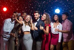 Holiday group selfie. Young friends having fun at New Year's Eve party and taking photo, copy space photo