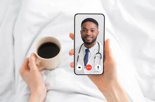 Woman Having Call With Doctor Lying In Bed At Home. Online Medical Consultation Concept. Virtual Clinic Helpline And Mobile Healthcare App. Physician Consulting Patient Distantly. Cropped photo
