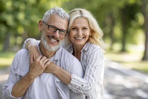 Happy Mature Spouses. Portrait of cheerful older couple hugging and smiling at camera, joyful senior man and woman embracing while posing together outdoors, enjoying romantic date outside, closeup photo