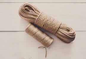Natural Jute Twine Roll, top view on white wood background. DIY Wrap Gift Hemp Rope Cord String Roll, supplies and tools for handmade hobby leisure photo