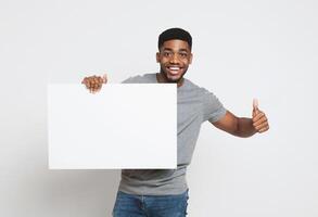 I like it. Smiling african-american man holding white blank board and showing thumb up, copy space photo