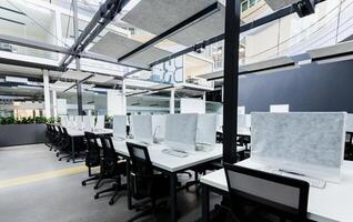 World pandemic, remote work. Light modern open space office with computers, no people photo