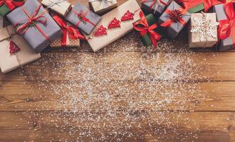 Christmas decoration, gift boxes and garland frame concept background, top view with copy space on wood table surface. Christmas ornaments and presents border with snow photo