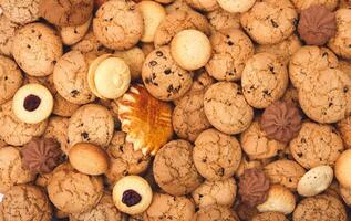 Cookies background. Sweet chocolate chips biscuits, shortbread and cookies with jam texture background. Oatmeal, chocolated drops and other sweets. Dessert, sweets for tea. Fattening sweets concept photo