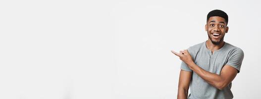 Unbelievable offer. Excited african american guy with open mouth pointing aside at empty space, panorama photo