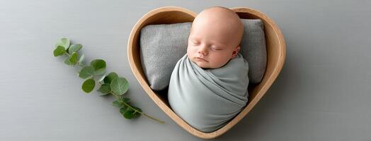 A baby in a heart shaped wooden box with leaves photo