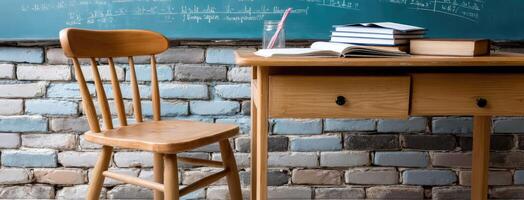 A wooden chair and desk in front of a blackboard photo