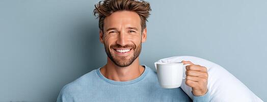 A man holding a coffee mug and pillow photo