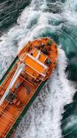 An orange cargo ship in the ocean photo