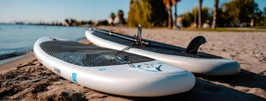 Two paddle boards on the beach near the water photo