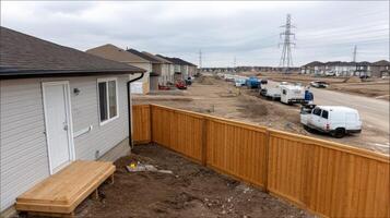 A view of a house under construction with a wooden fence photo