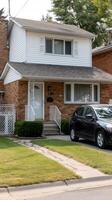 A car parked in front of a house with a fence photo