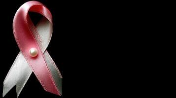 Pink ribbon with pearl on black background photo