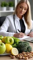 A woman sitting at a table with a laptop and a bowl of fruit photo