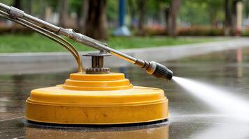 A yellow pressure washer spraying water on a wet street photo