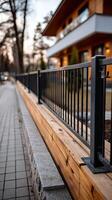 A fence is next to a sidewalk and a house photo