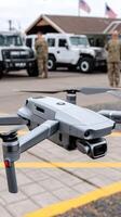 A gray drone is flying in front of a military vehicle photo