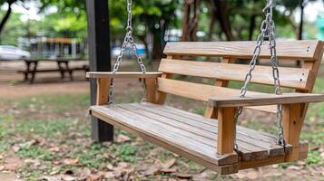 A wooden swing is hanging from a chain photo