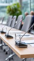 A conference table with microphones and papers on it photo