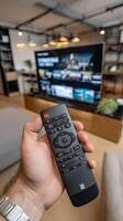 A person holding a remote control in front of a tv photo
