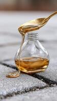 A spoon is pouring honey from a jar on the ground photo