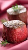 Two pieces of beef are sitting on a pink cloth photo