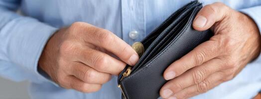 A man is holding a wallet with coins inside photo