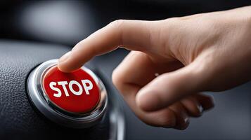 A person is pressing a red stop button on a car photo