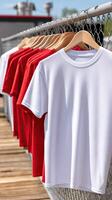 A row of white and red t-shirts hanging on a fence photo