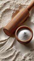 A wooden rolling pin and a bowl of flour photo