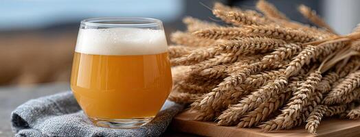 A glass of beer next to some wheat photo