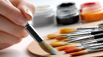 A person holding a brush and painting brushes photo