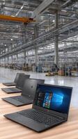 Three laptops are sitting on a table in an industrial area photo