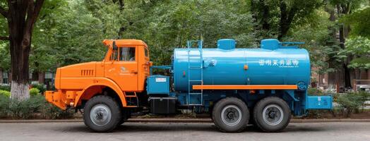 A large blue and orange water truck parked on the street photo