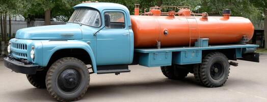 An old truck with an orange and blue tank photo