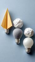 Three light bulbs with origami paper on them photo