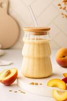 Refreshing Summer Peach Smoothie in a Stylish Glass Jar with Straw, Surrounded by Fresh Sliced Peaches and Oat Garnish photo