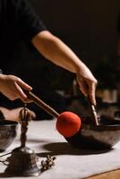 Practicing sound healing with singing bowls during a meditative session at a serene indoor setting with soft lighting photo
